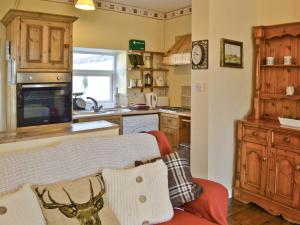 eine Küche mit einer Couch mit Kissen drauf in der Unterkunft Isabella Cottage in Heddon on the Wall