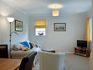 a living room with a couch and a television at Stonecot in Wootton Bridge