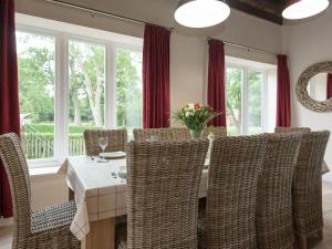 a dining room with a table and wicker chairs at Haven View - Ukc2301 in Wainfleet All Saints
