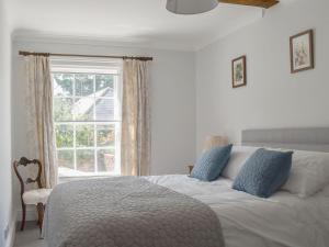 Un dormitorio con una cama grande y una ventana en The Townhouse, en Wimborne Minster