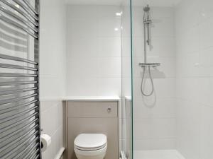 a bathroom with a toilet and a glass shower at The Townhouse in Wimborne Minster