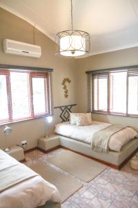 a bedroom with two beds and a chandelier at Klippan River Lodge in Groblersbrug