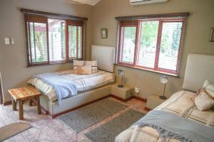 - une chambre avec 2 lits et 2 fenêtres dans l'établissement Klippan River Lodge, à Groblersbrug