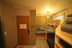 ein kleines Zimmer mit 2 Etagenbetten und einer Treppe in der Unterkunft Stitches House in Seoul