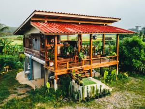 una pequeña casa con techo rojo en Na mong Homestay, en Nan