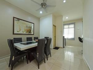 uma sala de jantar com uma mesa e cadeiras pretas em OYO Home 90532 Casa Azlinda Muslim Homestay Ii em Johor Bahru