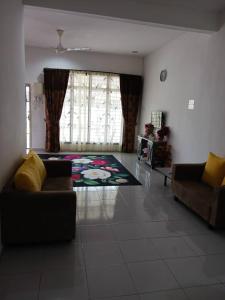 een woonkamer met een bank en een tapijt bij HOMESTAY AT-TAQWA BATU PAHAT in Batu Pahat