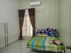 een slaapkamer met een bed en een raam erin bij HOMESTAY AT-TAQWA BATU PAHAT in Batu Pahat