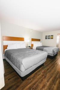 two beds in a hotel room with wood floors at The Atwood Hotel San Diego - SeaWorld/Zoo in San Diego