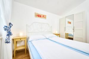 1 dormitorio con cama blanca y espejo en Elia Apartments, en Savudrija