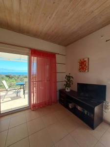 a living room with a sliding glass door with a view of a patio at Vasilopoulos Estate in Koroni