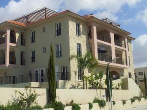 a large white building with a roof at Mazotos Panoramic Village in Mazotos
