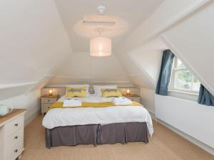 a bedroom with a large bed in a attic at Stable Yard Cottage in Selborne