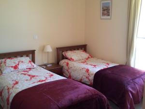a bedroom with two beds and a window at Mazotos Panoramic Village in Mazotos