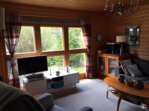 Lohja cottage في Lohja: غرفة معيشة مع تلفزيون بشاشة مسطحة وأريكة