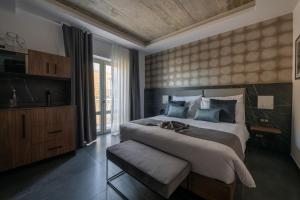 a bedroom with a large bed and a large window at Marea Boutique Hotels in Sliema