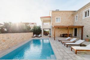 een zwembad voor een huis bij Olive Tree Apartments in Vodice