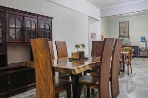 uma sala de jantar com uma mesa de madeira e cadeiras em SUPER OYO 92134 Bogor Guest House Syariah em Bogor
