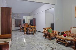 uma sala de estar com sofás, uma mesa e cadeiras em SUPER OYO 92134 Bogor Guest House Syariah em Bogor