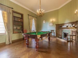 a living room with a pool table and a fireplace at Hockwold Hall in Hockwold cum Wilton