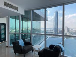 Luxurious Penthouses في دبي: غرفة معيشة مع كرسيين وإطلالة على مدينة
