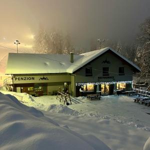 un bâtiment avec de la neige devant lui dans l'établissement Chata pod Lysou, à Malenovice