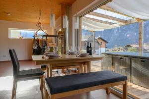 eine Küche mit einem Tisch und Stühlen sowie einem großen Fenster in der Unterkunft Ferienlodge MariAndl in Bad Goisern