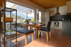 eine Küche mit einem Holztisch und Stühlen sowie einem großen Fenster in der Unterkunft Ferienlodge MariAndl in Bad Goisern