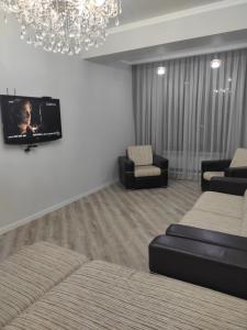 ビシュケクにあるСнять квартиру в Бишкекеのソファ2脚と薄型テレビのあるリビングルーム