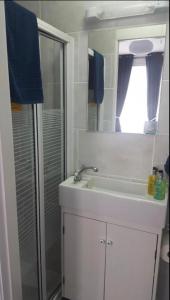 a bathroom with a white sink and a shower at By the Seaside in Blackpool