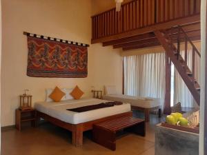 a bedroom with a large bed and a staircase at Giman Free Beach Resort in Pasikuda