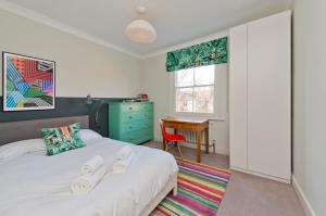 1 dormitorio con cama y escritorio. en Interior designed house with garden in North West London by UnderTheDoormat en Londres