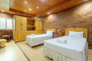 a bedroom with two beds and a stone wall at PJ Watergate Hotel in Bangkok