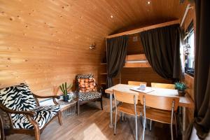 una stanza con tavolo e sedie in una cabina di Vakantiepark Vinkenhof a Schin op Geul