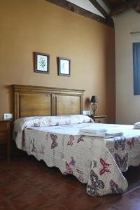 um quarto com uma cama e duas fotografias na parede em Casa Rural Concejo 1 em La Adrada