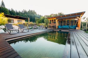 a house with a pool and a deck with chairs at Villa Blumegg in Hermagor