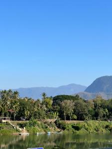 - une vue sur une rivière avec des montagnes en arrière-plan dans l'établissement NamKhan Riverside, à Luang Prabang