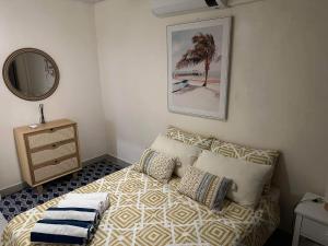 a bedroom with a bed with pillows and a mirror at Bamboo Villa in Port Vila