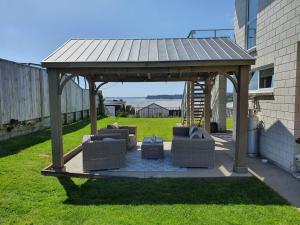 a gazebo with couches in a yard at Omokoroa Sea View Apartment in Omokoroa