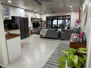 uma cozinha e sala de estar com um sofá e uma mesa em Bamboo Villa em Port Vila