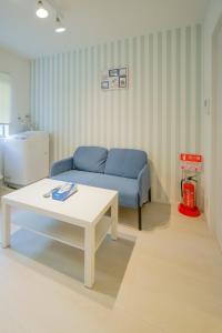 a living room with a blue couch and a table at HANASTAY花渓居 · 楓（KAEDE) in Osaka