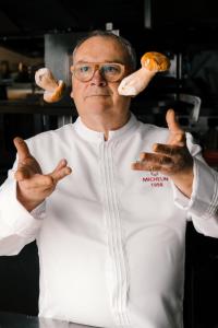 un chef sosteniendo dos pulgares arriba mientras sostenía la comida en Le Manoir du Lys, The Originals Relais (Relais du Silence), en Bagnoles de l'Orne