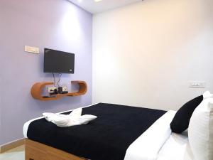 1 dormitorio con 1 cama y TV en la pared en Hotel Stayinn Thanjavur, en Thanjāvūr