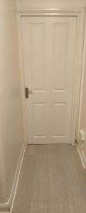 a white door in a room with a tile floor at Heronsgate GH009 in Abbey Wood