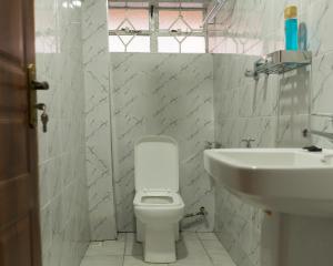 a bathroom with a white toilet and a sink at Guesthouse in Kamakis Eastern Bypass in Ruiru