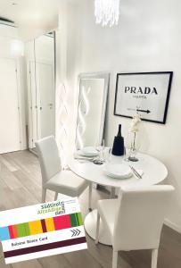 a white dining room with a white table and chairs at Chic In The City in Bolzano