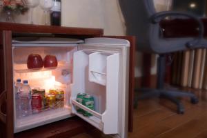 an open refrigerator with apples and drinks in it at Vong Xua Boutique Hotel in Hanoi