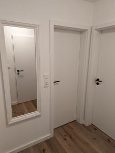 une chambre avec deux portes et un miroir dans l'établissement Dünengras, à Horumersiel