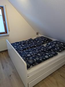 - une chambre avec un lit et une couette noire et blanche dans l'établissement Dünengras, à Horumersiel