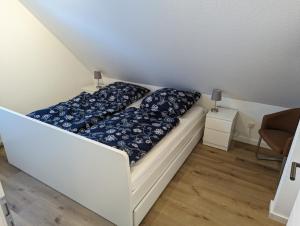 - un lit blanc avec des oreillers bleus dans l'établissement Dünengras, à Horumersiel